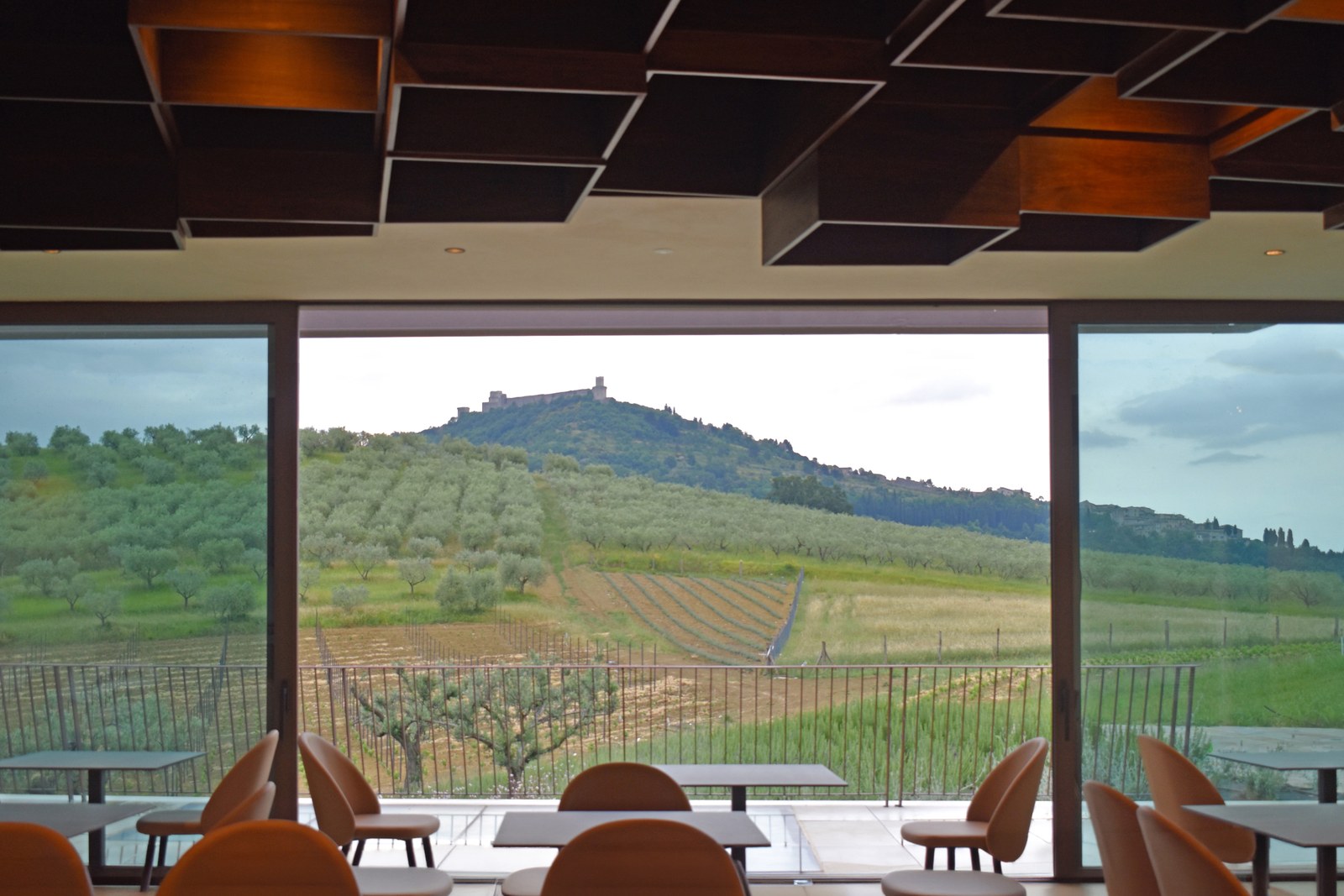Dining hall of Agriturismo Alma framing the hill of Assisi