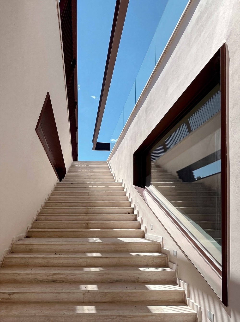 Travertine stair ascending between walls